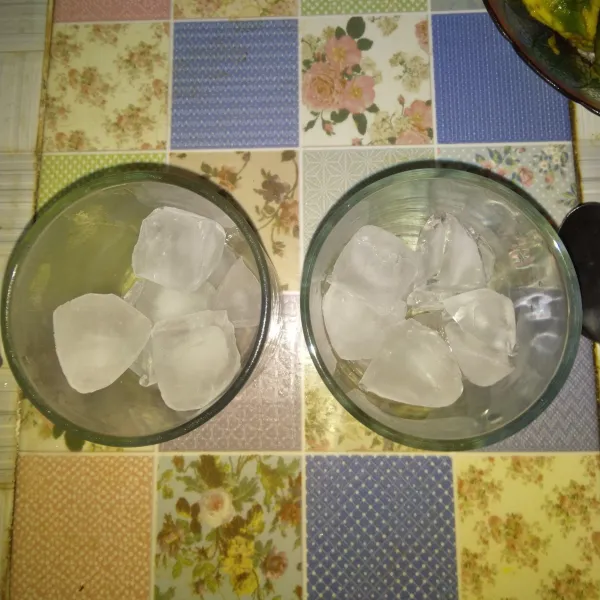 Siapkan gelas saji, masukkan secukupnya es batu.