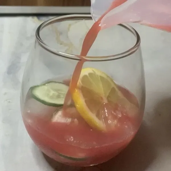 Siapkan gelas saji kemudian isi dengan es batu, irisan timun & lemon lalu tuang jus semangka.
