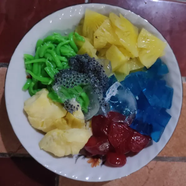 Masukkan agar-agar, nanas, kolang kaling, cendol,  tape singkong dan biji selasih.