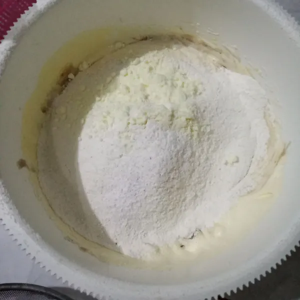 Masukkan tepung terigu, susu bubuk dan baking powder, aduk pelan dengan spatula.
