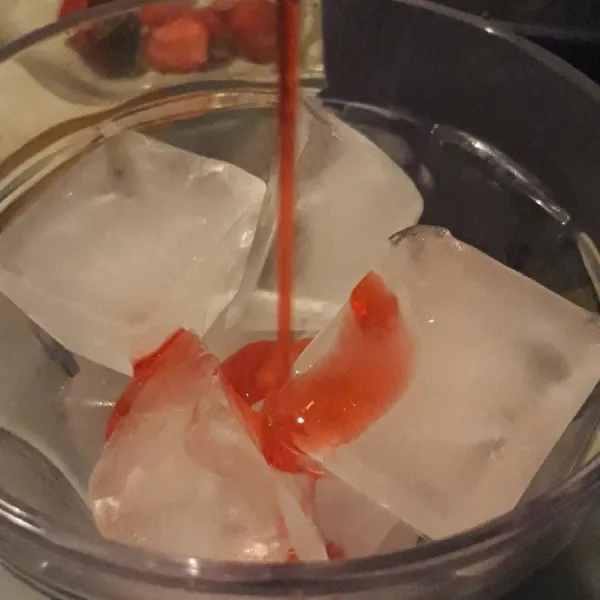 Siapkan es batu dalam gelas saji.Tuang syrup merah secukupnya