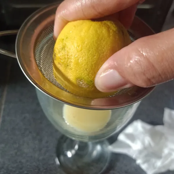 Potong 2 bagian lemon, ambil ½ buah, peras lemon dan ambil airnya.