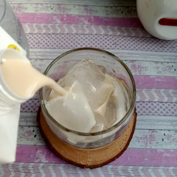 Lalu masukkan oat milk ke dalam gelas yang berisikan es batu.