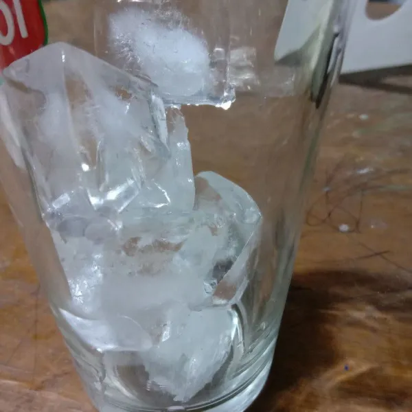Siapkan gelas saji, tambahkan es batu.