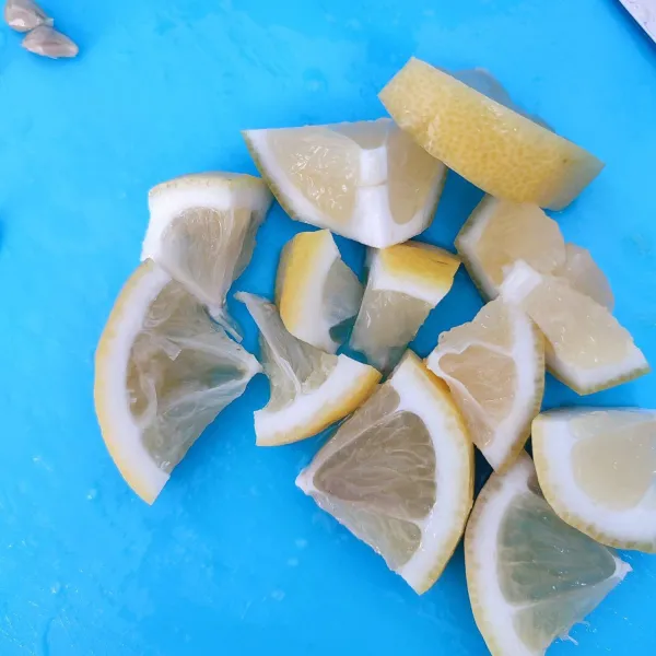 Cuci bersih lemon dengan sabun untuk mencuci sayur. Kemudian potong kecil dan pisahkan bijinya.