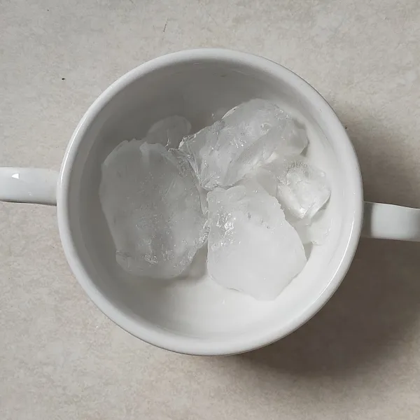 Siapkan gelas saji, lalu beri es batu secukupnya.
