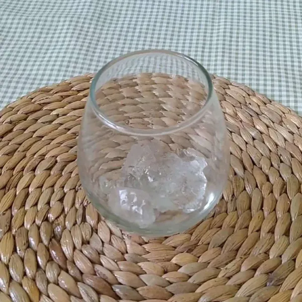 Masukkan es batu ke dalam gelas saji.