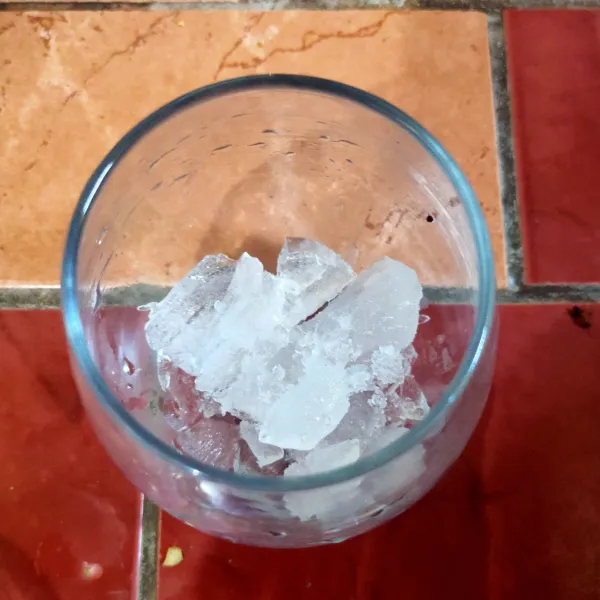 Siapkan gelas saji, masukkan es batu secukupnya.