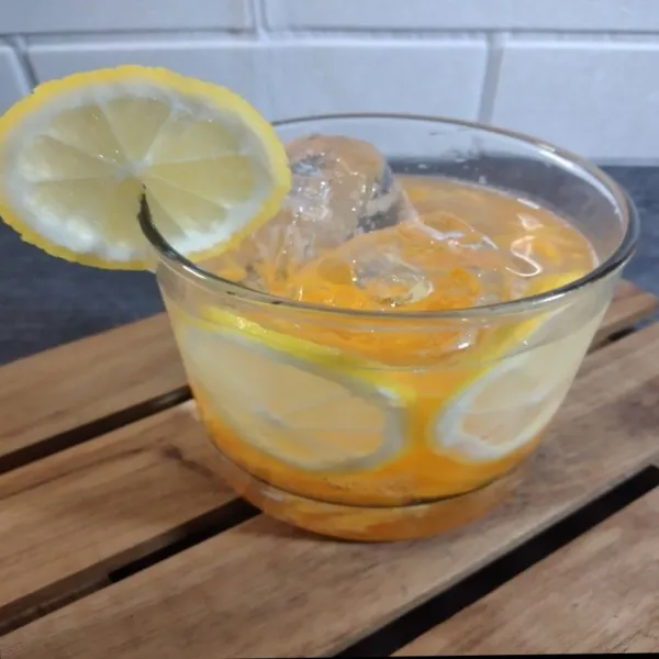 Tambahkan irisan lemon ke dalam gelas, lalu aduk sebelum disajikan.