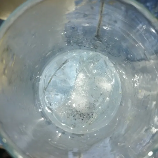 Siapkan gelas saji, masukkan es batu secukupnya, tambahkan air soda hingga tingginya setengah dari tinggi gelas.