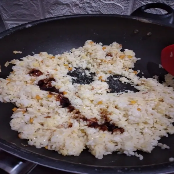 Masukkan nasi dan aduk, tambahkan saos tiram dan kaldu bubuk, aduk hingga tercampur rata.