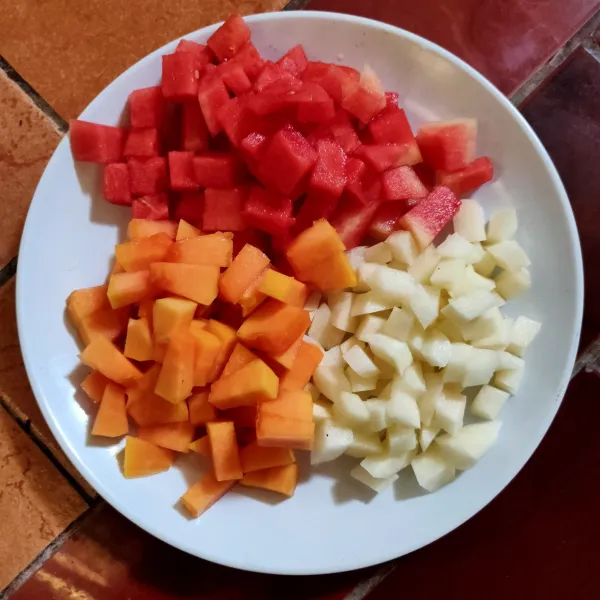 Potong dadu buah semangka, pepaya dan bengkuang lalu sisihkan.