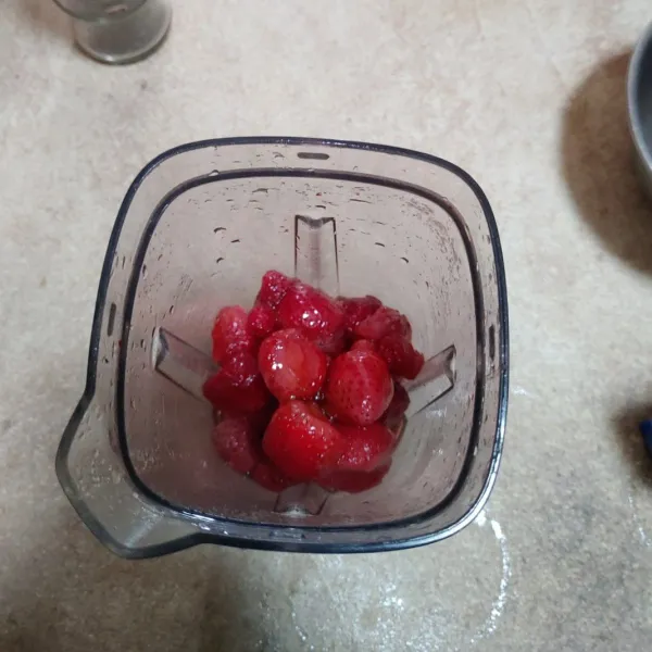 Masukkan buah strawberry dan madu ke dalam blender.