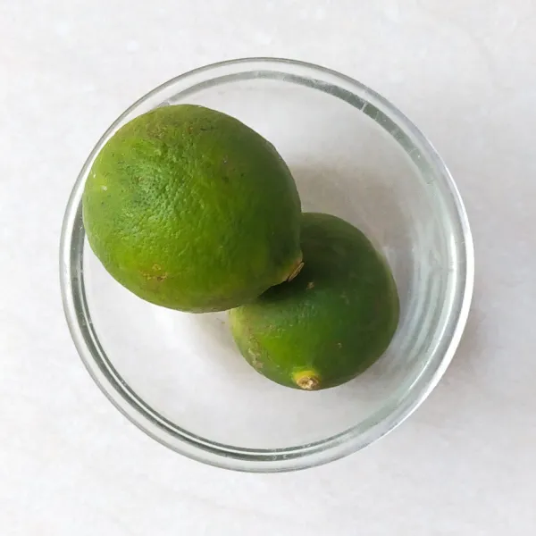 Siapkan dua buah jeruk nipis, lalu ambil airnya.