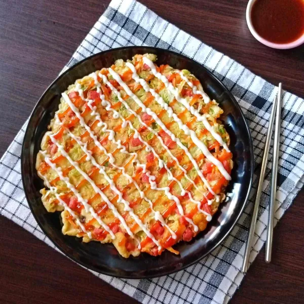 Sajikan okonomiyaki dengan saus.