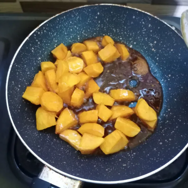 Masukkan ubi goreng. Aduk cepat sampai terbalut rata dengan karamel.
