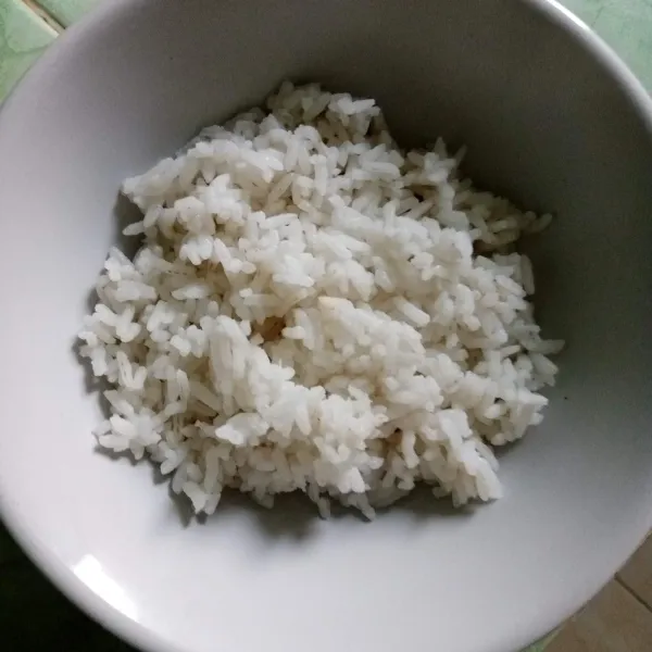 Tata nasi di mangkuk, beri dadar telur dan tahu lalu sajikan.
