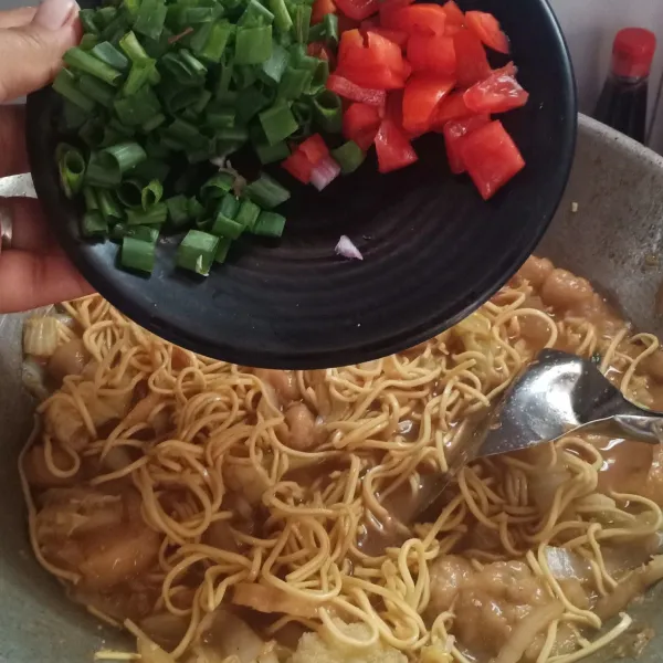 Terakhir sebelum mie matang tambahkan irisan tomat, daun bawang dan irisan cabe sesuai selera.