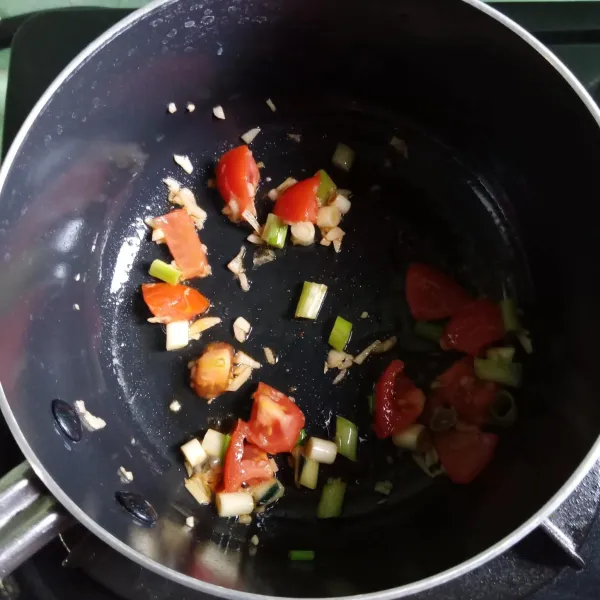 Masukkan tomat dan daun bawang, aduk-aduk tuang air. Bumbui garam, gula, lada, kaldu bubuk.