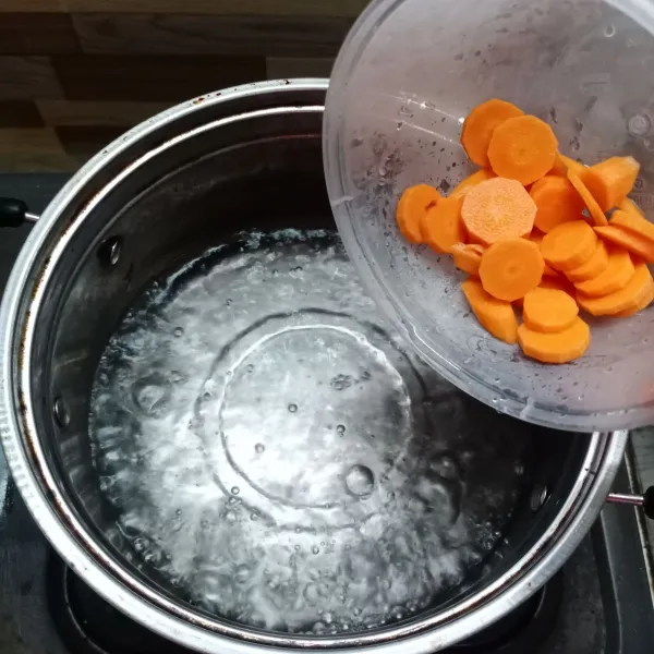 Didihkan air di panci, kemudian masukkan wortel. Masak sampai setengah matang.