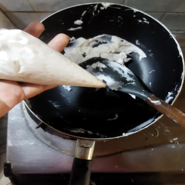 Bagi beberapa bagian sesuai selera dan tambahkan pasta pandan dan pewarna, masing-masing sambil diaduk rata. Lalu masukkan adonan ke dalam plastik segitiga.