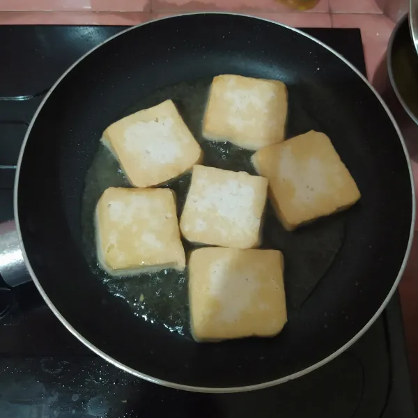 Panaskan fry pan, tuang minyak kemudian masukkan tahu. Panggang hingga kecokelatan. Angkat dan tiriskan.