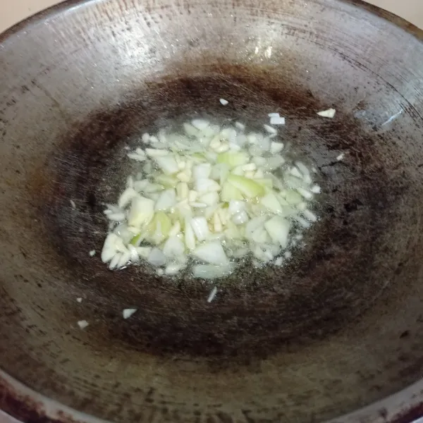 Tumis bawang Bombay dan bawang putih sampai harum menggunakan minyak goreng.