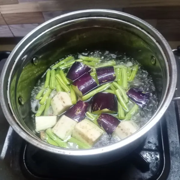 Masukkan kacang panjang dan terong. Masak sampai setengah empuk.