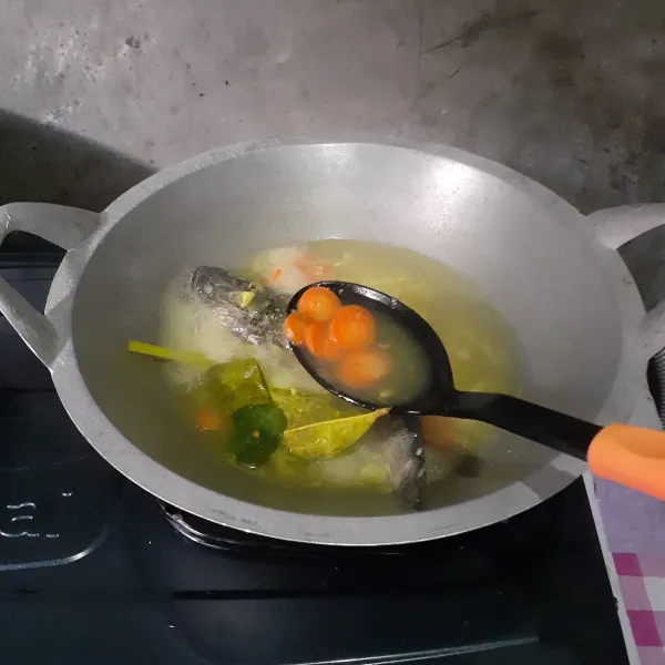Masukkan wortel. Bumbui dengan garam, kaldu, dan gula. Masak sampai wortel empuk dan ikan matang.