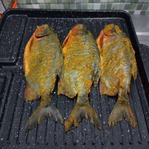 Panggang ikan bawal yang telah di marinasi hingga matang diatas grill pan dengan api kecil.