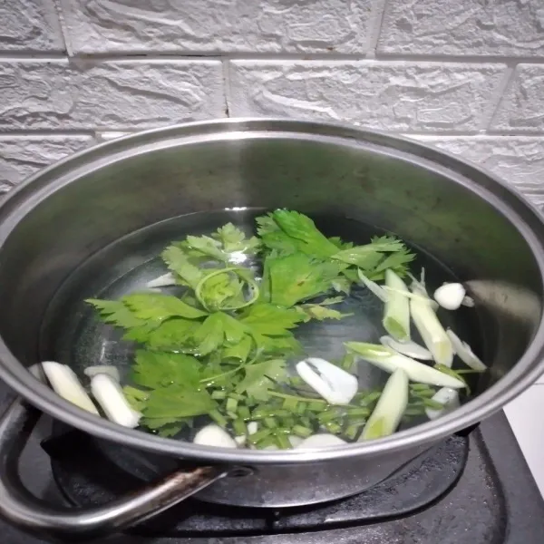 Masak air, masukkan irisan bawang putih, daun bawang dan seledri.