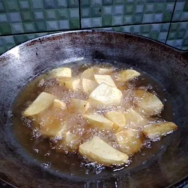 Kupas dan potong kentang jadi 4 bagian kemudian goreng hingga matang.