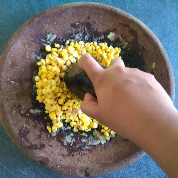 Masukkan jagung manis secara bertahap lalu ulek kasar. Lakukan sampai jagung manis habis lalu pindahkan ke dalam wadah.