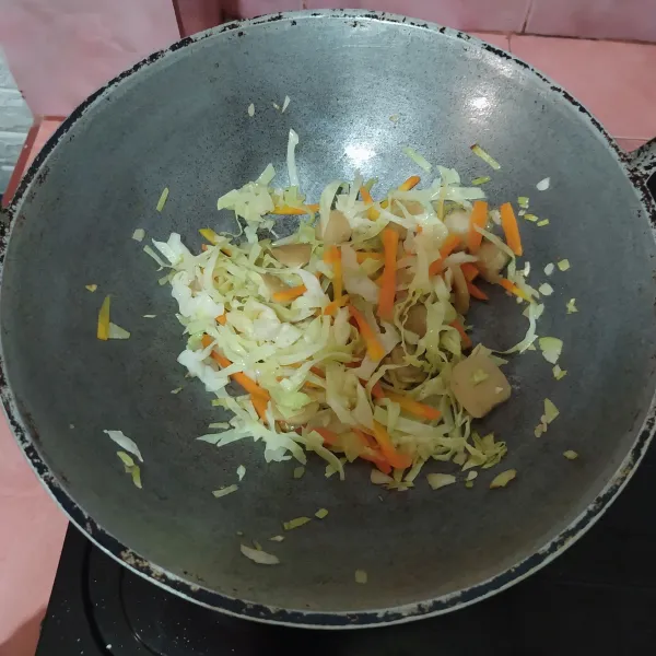 Masukkan wortel dan air, setelah wortel agak lunak masukkan kubis dan daun bawang.
