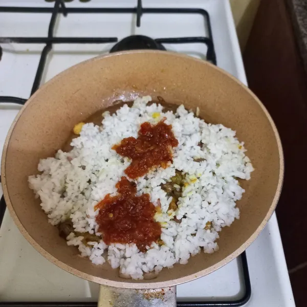 Masukan nasi pada wajan, tambahkan garam, kaldu jamur dan sambal, aduk rata.