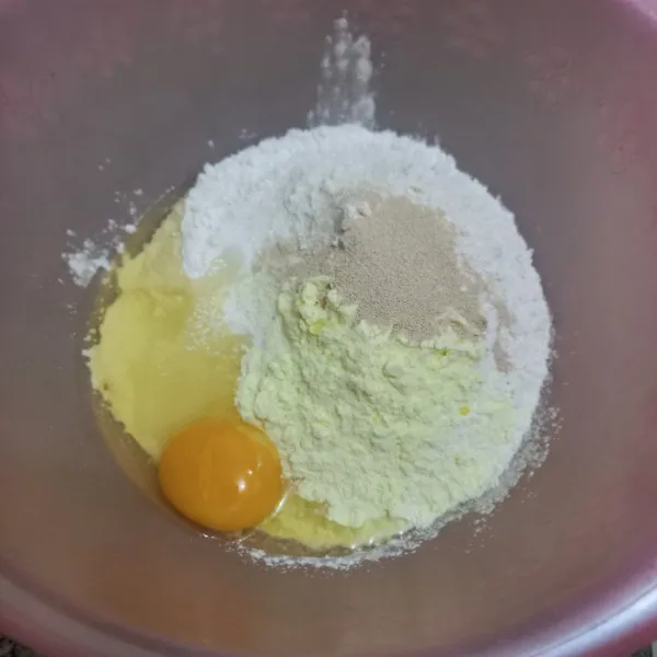 Dalam wadah campur tepung terigu, gula pasir, ragi instan, susu bubuk, telur ayam dan air, uleni hingga rata.