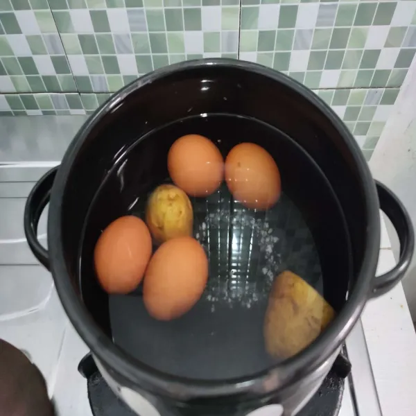 Rebus telur dan kentang hingga matang, lalu sisihkan.