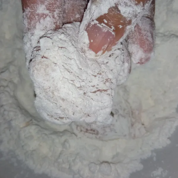 Setelah itu guling-gulingkan ke dalam campuran tepung terigu yang masih kering. Lakukan sampai semua ayam terbalut tepung sampai rata.