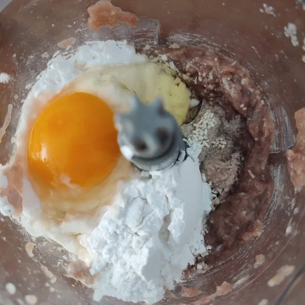 Tambahkan tepung tapioka, telur ayam, garam, merica bubuk dan kaldu jamur. Blender kembali hingga tercampur rata.