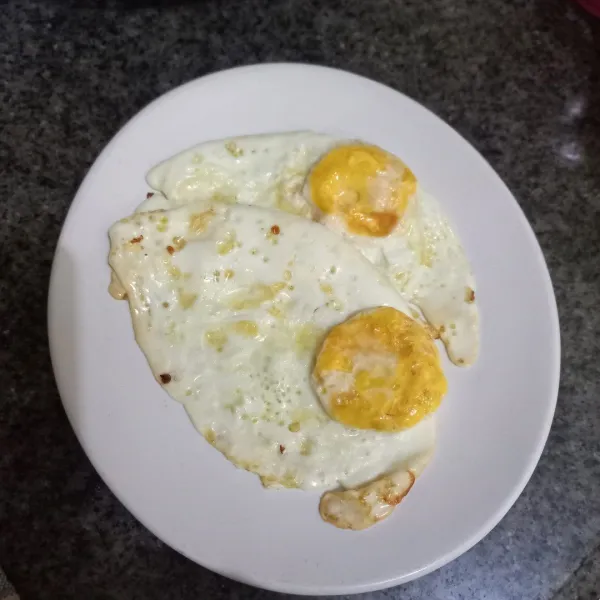 Siapkan piring, tata ceplok telur di atasnya.