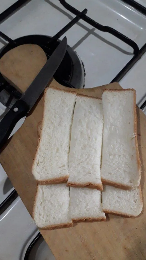 Siapkan 2 lembar roti lalu potong memanjang.