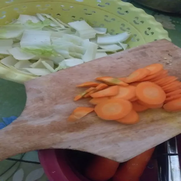 Potong-potong sayuran dan pisahkan batang sawi.