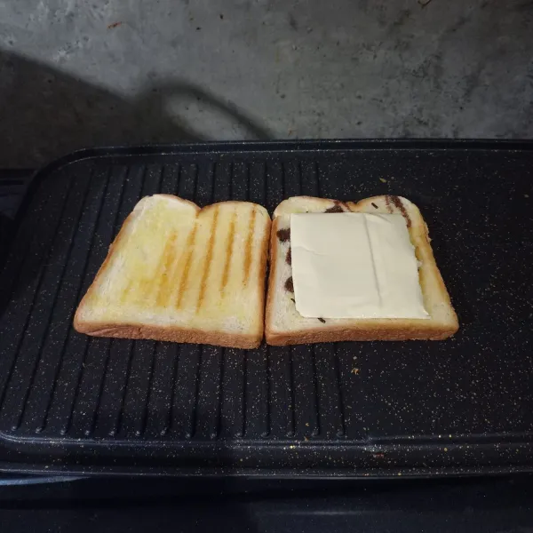 Tambahkan keju slice dan tutup dengan roti yang satunya. Potong dan sajikan roti.