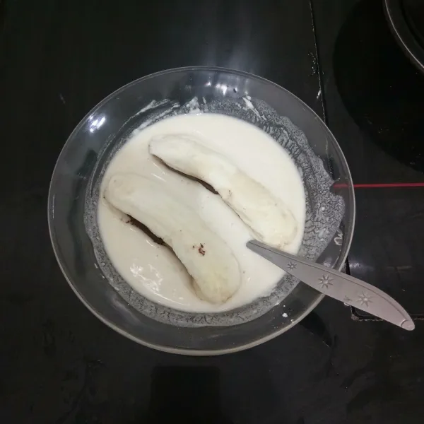 Setelah itu celupkan pisang isi cokelat ke dalam adonan terigu dan balur hingga rata.