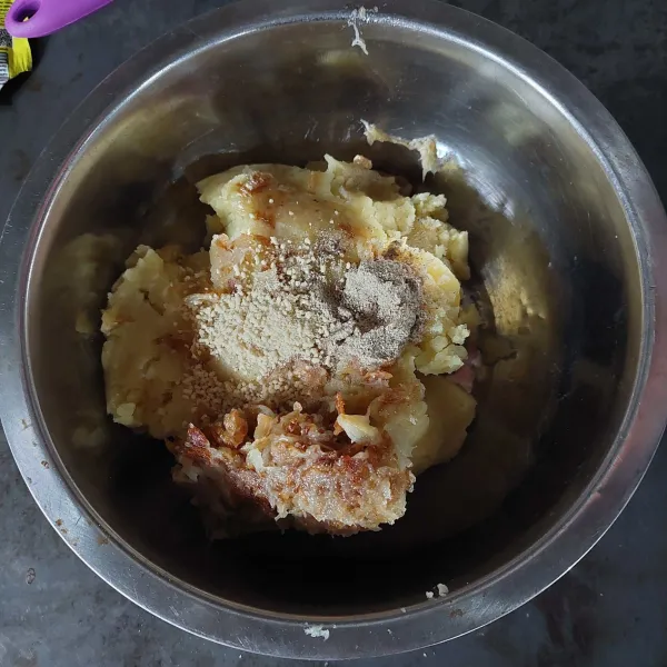 Selanjutnya masukkan bawang merah dan bawang putih yang telah dihaluskan ke dalam adonan perkedel, lalu tambahkan daun bawang, merica bubuk, garam, dan kaldu bubuk, kemudian aduk hingga bumbu tercampur rata.
