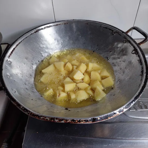 Bersihkan dan potong-potong kentang, lalu goreng sampai matang, kemudian angkat dan tiriskan.