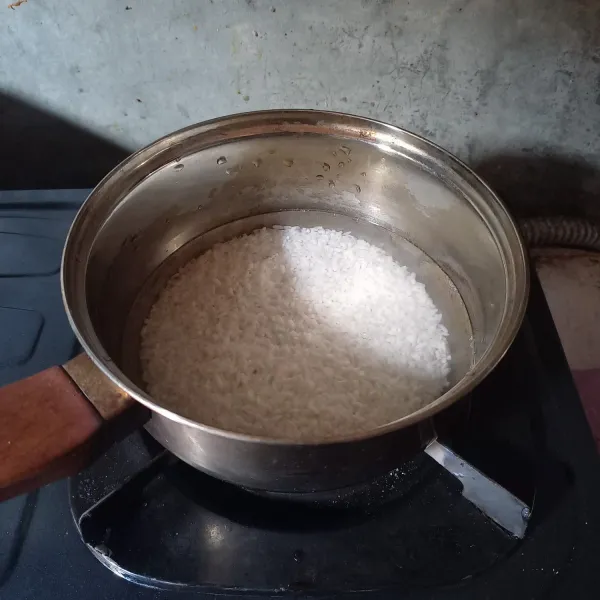 Masukkan beras yang sudah dicuci ke dalam panci, lalu tuang 300 ml air. Masak dengan api sedang, sesekali diaduk supaya tidak gosong di bagian bawah.
