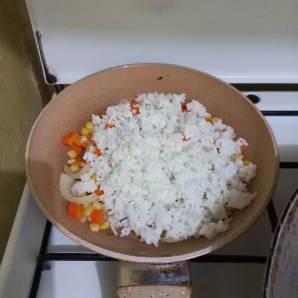 Masukkan nasi putih pada wajan, lalu aduk rata.