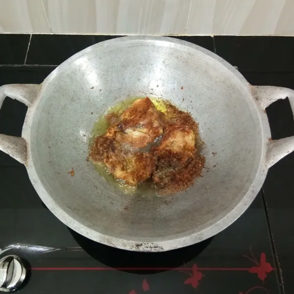Kemudian goreng ayam beserta kelapanya dalam minyak panas hingga matang kecokelatan, lalu angkat dan tiriskan.