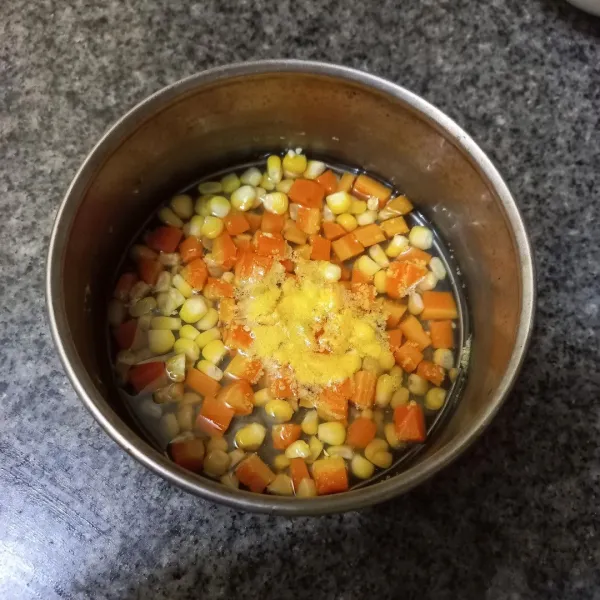 Rebus jagung manis dan wortel yang sudah dipotong dadu hingga matang, kemudian tiriskan.